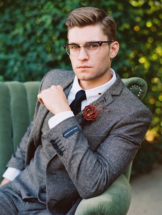 a vintage groom's outfit with a grey tweed three-piece suit, a white shirt, a black tie and stylish glasses