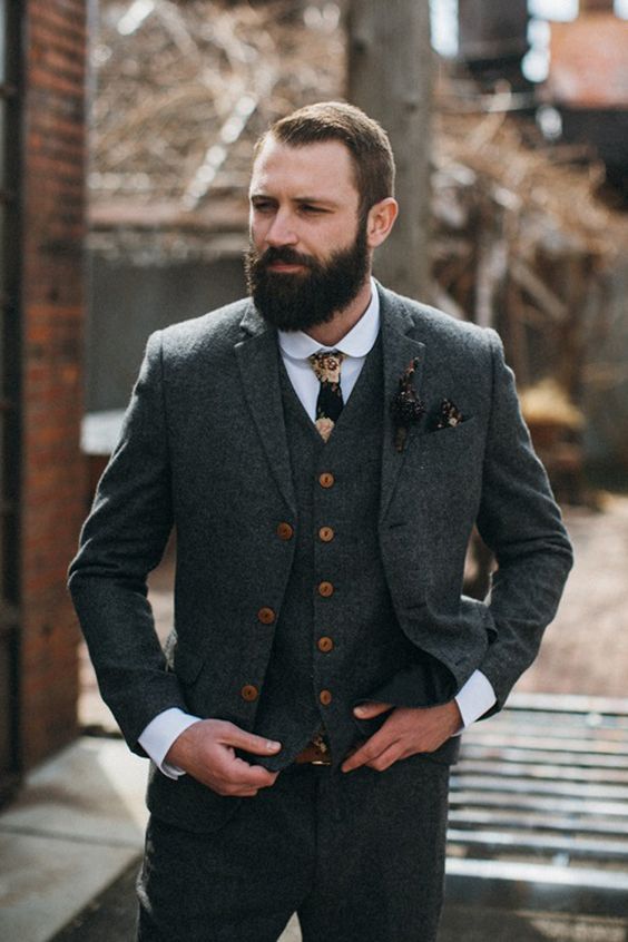 a vintage-inspired groom's look with a grey three-piece pantsuit, a white shirt, a printed tie and dark accessories