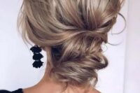 a wavy and chic low updo with a volume on top and some waves is a cool option for a modern refined look