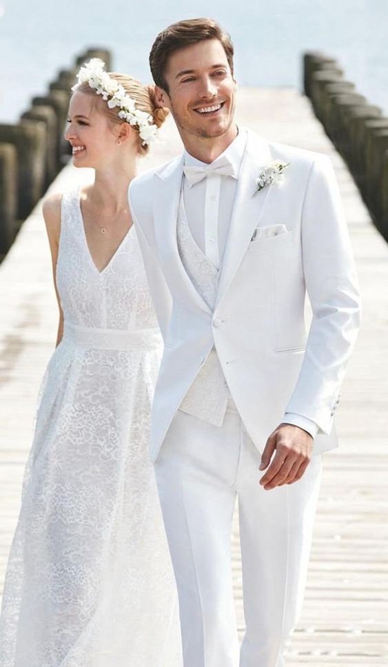 a white modern groom's look with a three-piece suit with a patterned waistcoat and a bow tie is amazing
