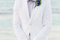 a white suit, a lavender shirt and a bold boutonniere for a beach groom look