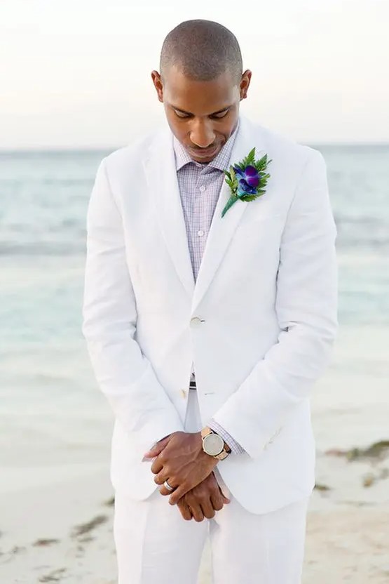 a white suit, a lavender shirt and a bold boutonniere for a beach groom look