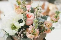 a wooden crate with fresh flowers, greenery and twigs is a simple and cute idea of a rustic wedding centerpiece