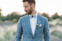 an elegant blue grey linen suit, a white shirt, a light blue bow tie and a boutonniere for a spring or summer wedding