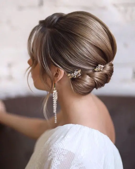 an exquisite twisted low updo with a sleek volume on top and some waves down is a catchy and chic idea