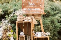 beautiful and relaxed rustic wedding decor with crates, blooms and greenery, candle lanterns and some signs