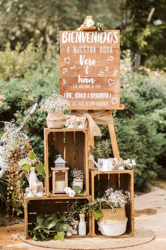 beautiful and relaxed rustic wedding decor with crates, blooms and greenery, candle lanterns and some signs