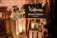 bright and cool rustic wedding decor with crates, pink blooms and greenery and pillar candles is cool