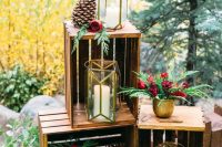 bright wedding decor with crates, greenery and burgundy roses, candle lanterns and large pinecones