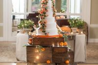 crates stacked to hold the wedding cake, with LED lights and fruit around for a wedding