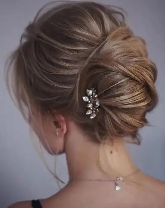 one more catchy idea of a messy chignon and twists and locks down and a small rhinestone hairpiece