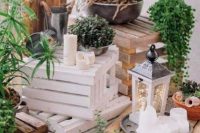 pretty rustic decor with crates, potted plants and succulents, pillar candles and a lantern with lights