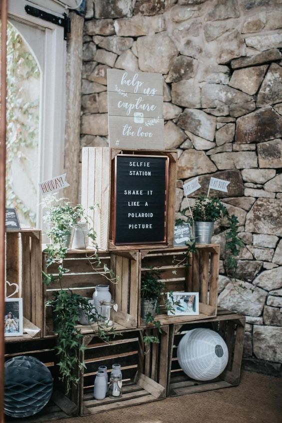 rustic wedding decor of crates, greenery, paper lamps, family pics and signs is amazing for rustic wedding
