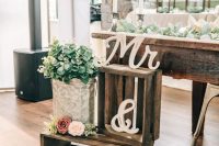 rustic wedding decor of crates with succulents and blooms, with calligraphy monograms is amazing