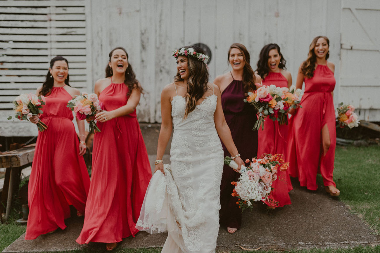 The bride was wearing a lace sheath dress on spaghetti straps and a floral crown, the bridesmaids were rocking coral dresses
