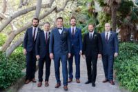 The groomsmen were rocking navy and black suits with plum-colored ties