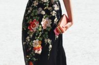 09 a black maxi gown with embroidered flowers, a coral clutch and a belt for a chic fall look