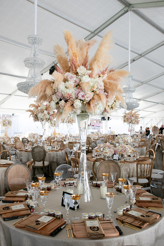 The reception tables were decorated with lush centerpieces with pampas grass, pink and white roses and gold touches