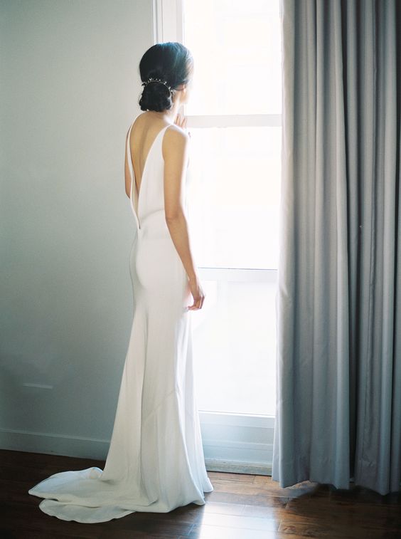 a modern slip wedding gown with a plunging back and a small train for a super elegant look