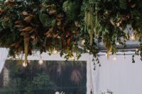 12 a very lush greenery wedding decoration with magnolia leaves and bulbs hanging down for a bit wild look