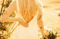 15 a minimalist mermaid wedding dress with wide straps and a cutout back and a beige hat