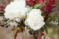 18 a fall wedding centerpiece with white blooms, herbs, leaves, berries and fruits in an elegant silver vase