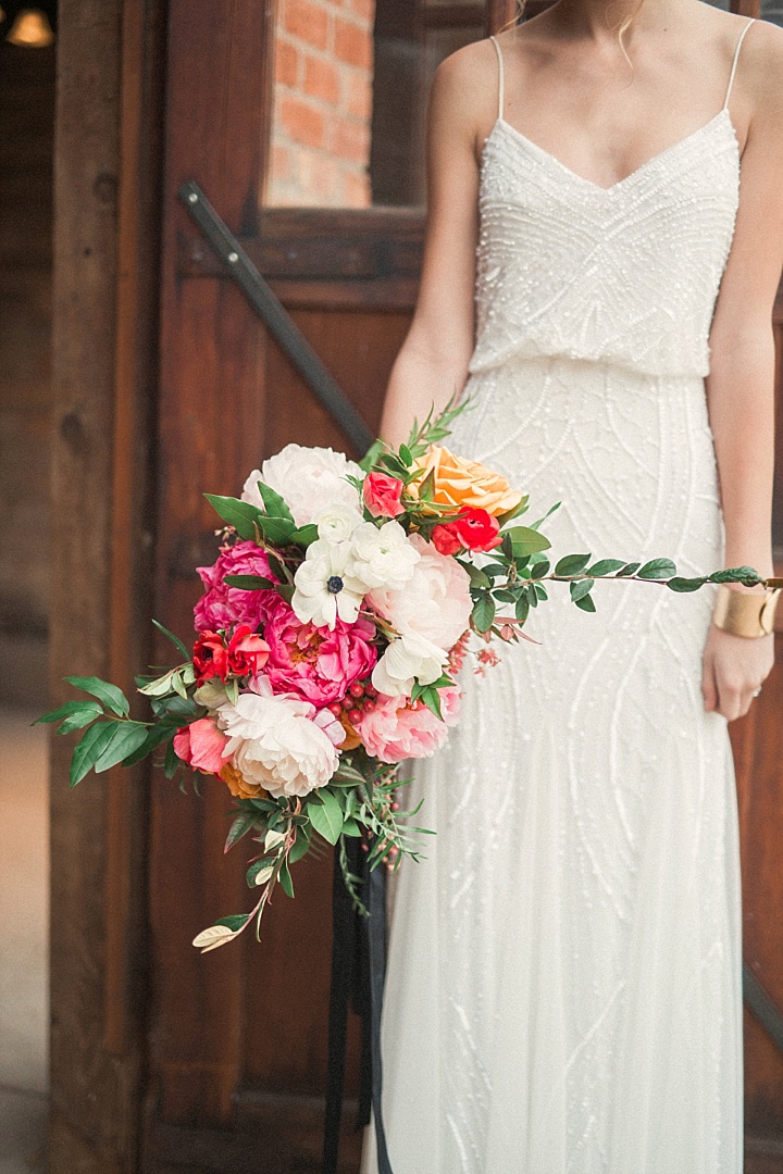 a gorgeous all-sparkling slip wedding dress with a V-neckline and a bright wedding bouquet