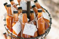 20 miniature bottles of hot sauce gathered in a basket and used as wedding favors with personalized tags