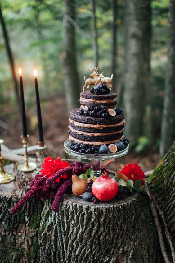 a naked chocolate fall wedding cake topped with blackberries, figs and gold deer for a woodland location