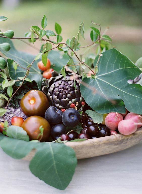 a cute fall wedding centerpiece done of veggies, fruits and some foliage for a rustic or garden wedding