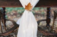 23 a white fabric table runner decorated with a single leaf and twine looks very refined and fall-like