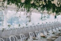 25 a super elegant suspended wedding decoration of greenery and white blooms makes centerpieces unnecessary