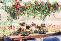 26 a super lush greenery and bright bloom decoration over the reception table for a bright boho wedding