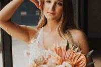 a gorgeous tropical bridal crown with orange dried fronds and some white leaves and a matching bouquet for a tropical bride