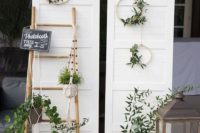 03 a natural rustic photo booth with an door backdrop, greenery, lanterns and wicker vases