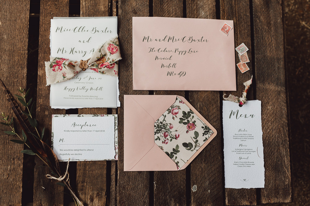 The wedding invitation suite was done in soft pink and with florals and stamps