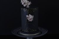 05 a breathtaking matte black wedding cake with gilded scales and real sakura flowers for decor