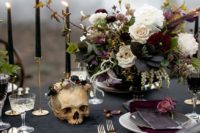 05 a decadent Halloween tablescape with moody florals, a black tablecloth and candles, elegant silver cutlery and grey plates