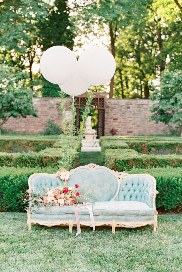The beautiful garden was spruced up with a refined blue sofa and white baloons