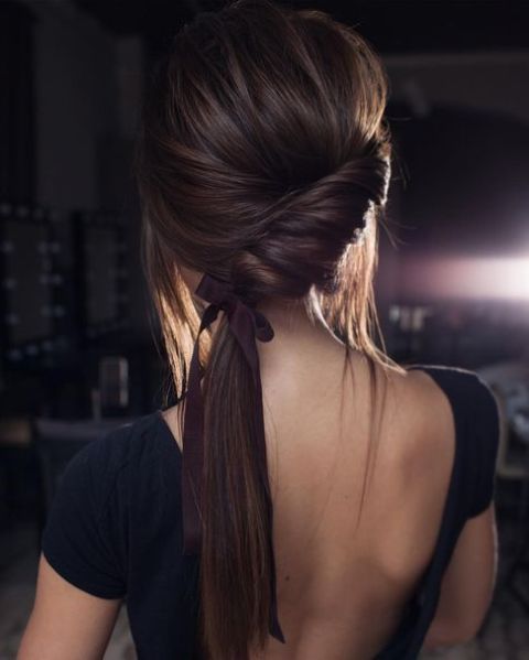a low twisted ponytail with a bump, locks down and a ribbon is a chic modern option