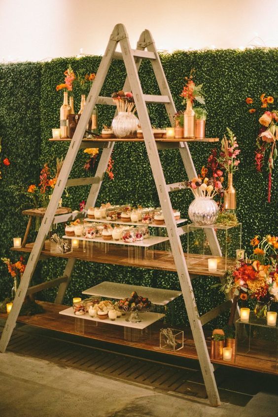 a stylish modern meets rustic dessert table on a ladder using acrylic stands