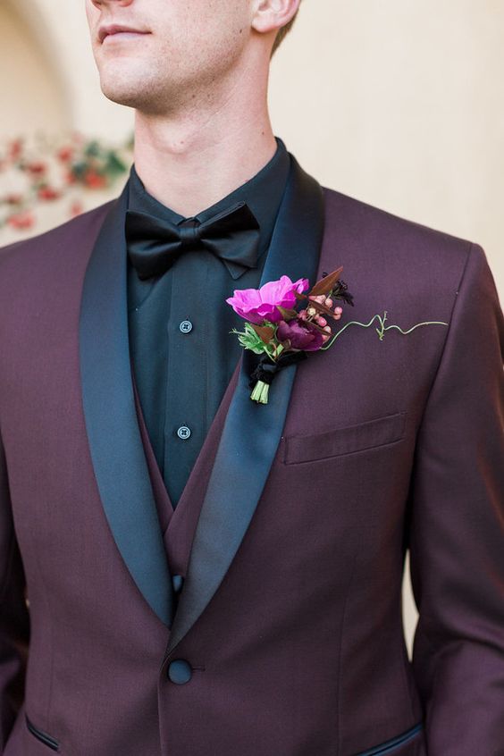 a stylish three-piece suit in burgundy with black lapels and a black bow tie for a moody look