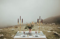 08 The tablescape was modern yet wild, with a grey table runner, burgundy candles, gilded touches and colored glass