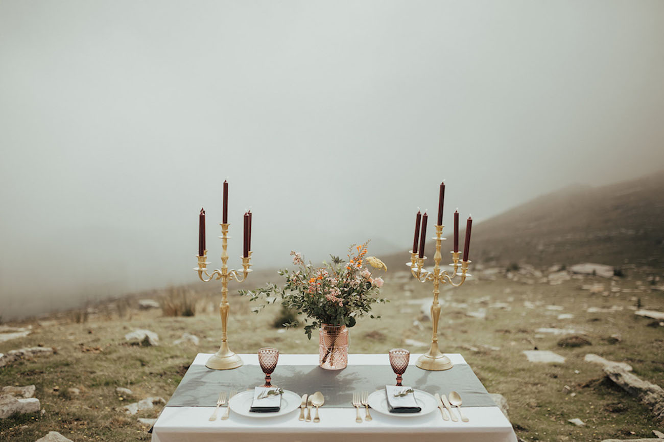 The tablescape was modern yet wild, with a grey table runner, burgundy candles, gilded touches and colored glass