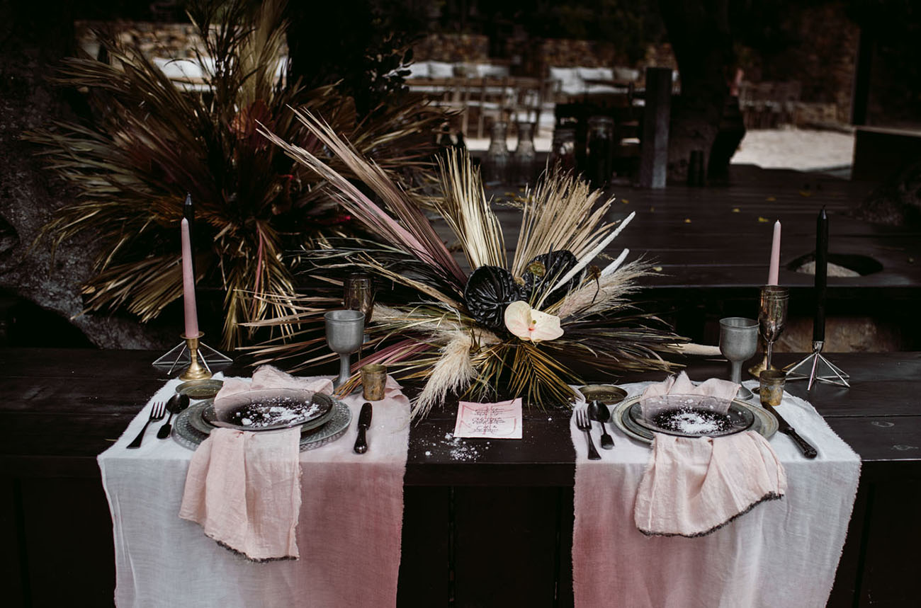 The wedding tablescape was done with a dark-stained table, ombre dyed pink placemats and napkins ples greys