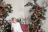 08 a luxurious floral photo booth with a dusty pink love seat and lush florals and greenery on both sides