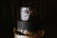 08 an impressive black and gold wedding cake with painted skulls topped with blackberries and eucalyptus