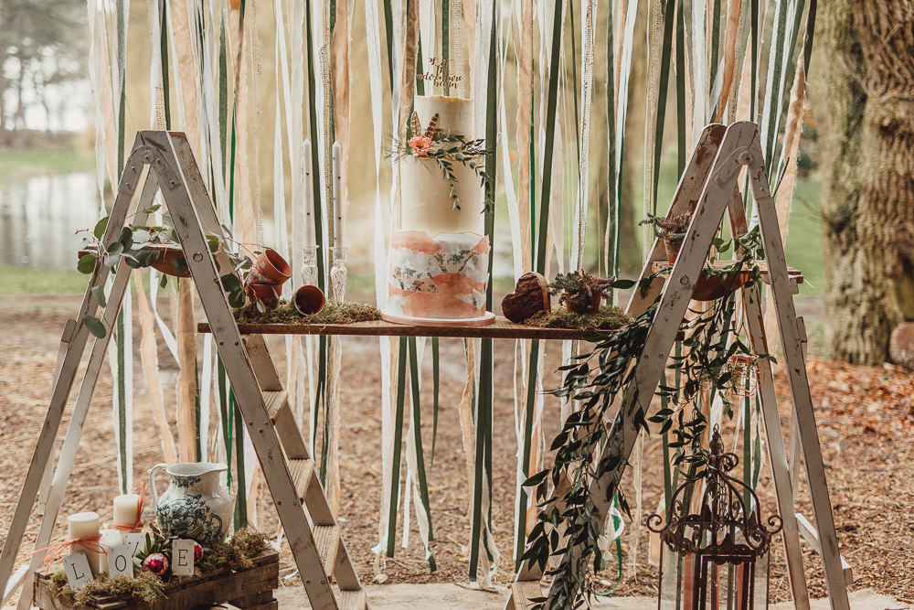The wedding cake was displayed with using two ladders, moss and pots and candles
