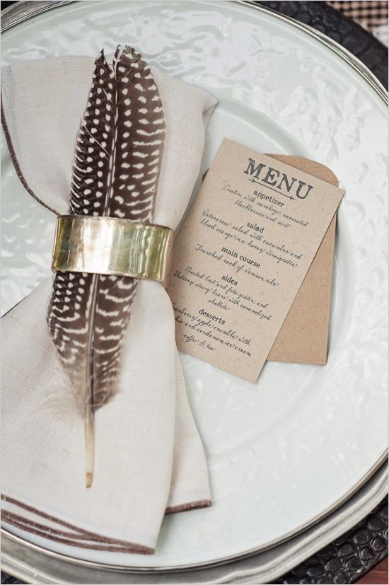 add a feather and a metallic napkin ring to make the place setting cooler