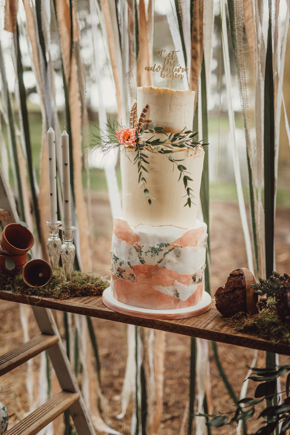 The cake was a semi naked one with greenery, feathers, blooms and a calligraphy topper